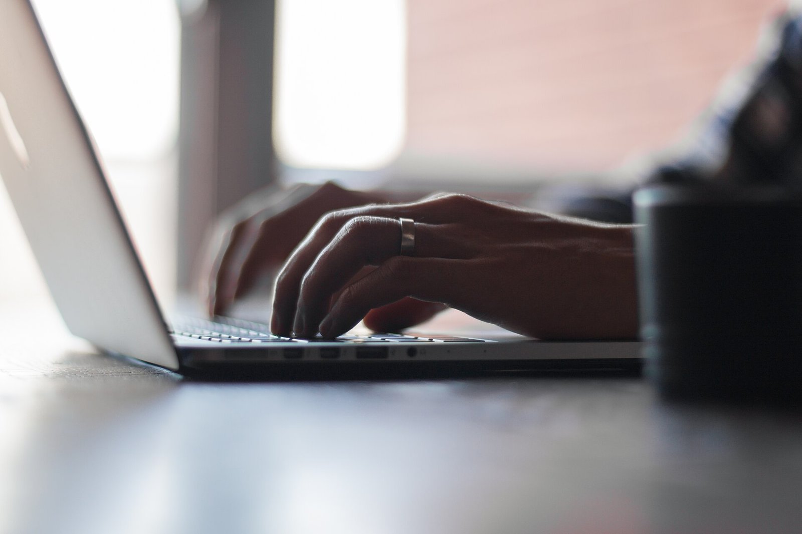 Hands typing on a laptop keyboard