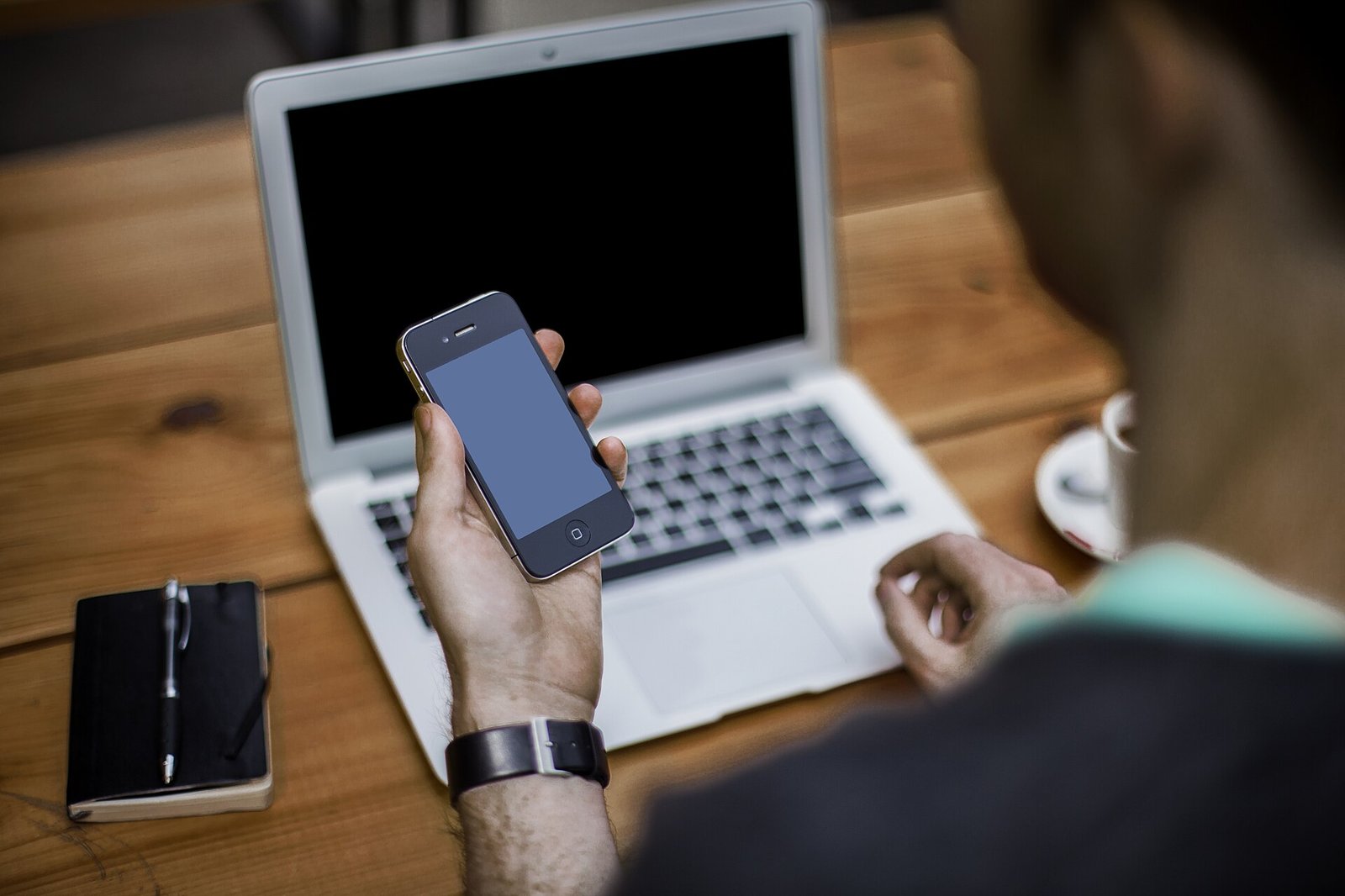 Person with smartphone and laptop